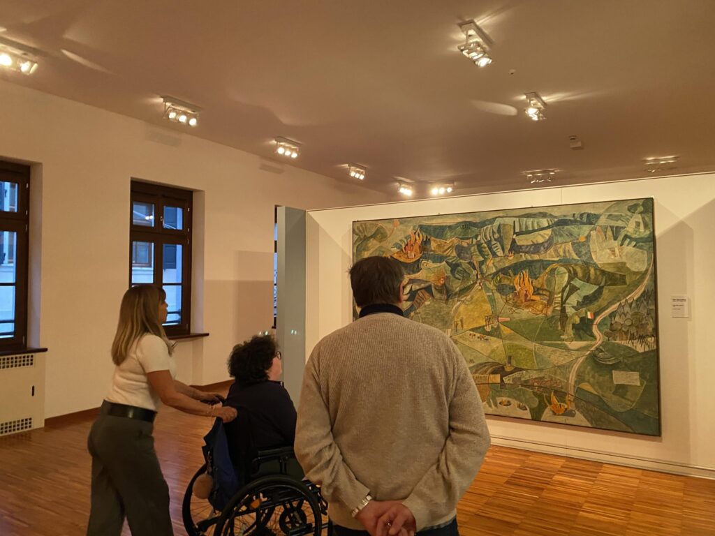 Persone osservano un’opera d’arte in una galleria.