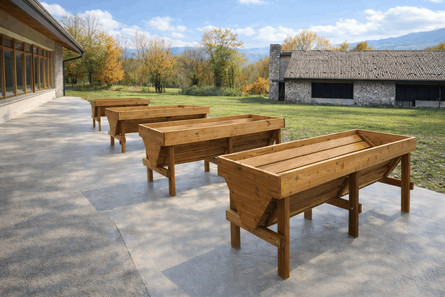 Quattro contenitori coltivabili rialzati per orto tintorio accessibile, installati alla Comunità Piergiorgio di Caneva di Tolmezzo per favorire l’inclusione di persone con disabilità, con prato e edifici rurali sullo sfondo.