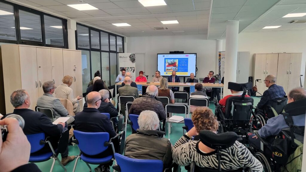 Panoramica della sala durante l'inaugurazione del Centro di Mobilità, con il pubblico seduto e il tavolo dei relatori sullo sfondo