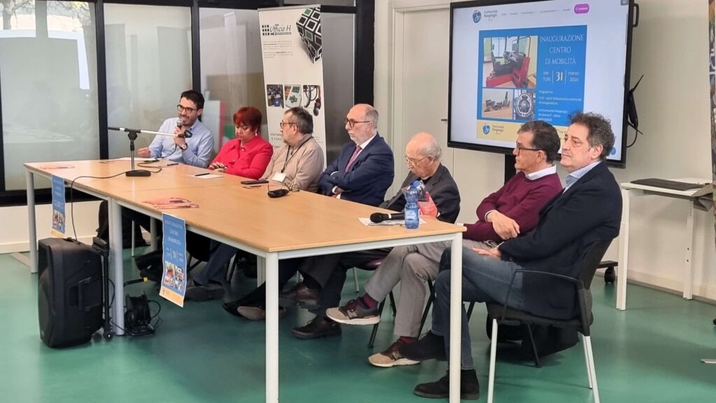 Il tavolo dei relatori durante gli interventi, con la presentazione proiettata sullo schermo