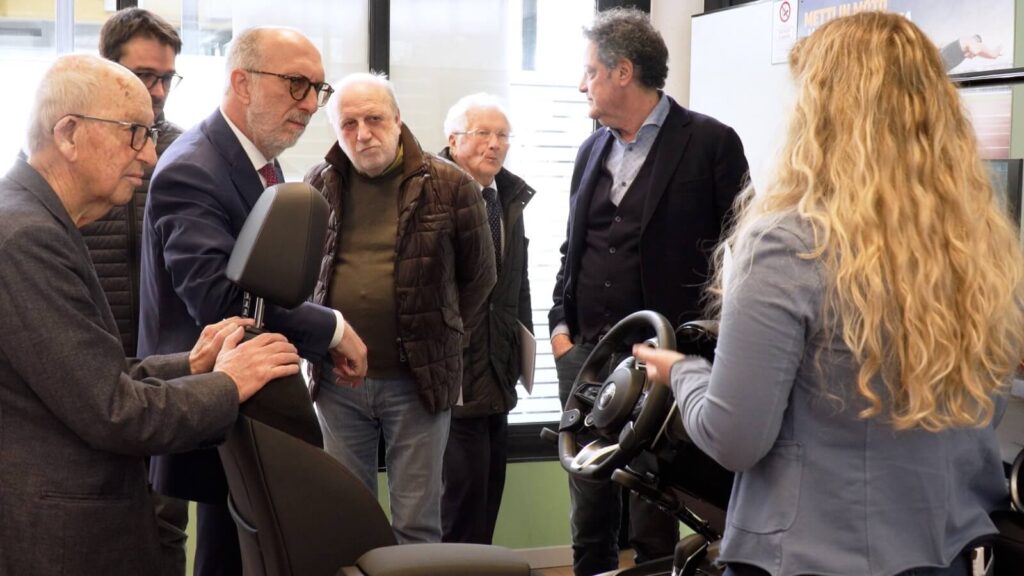 I presenti esaminano da vicino il simulatore di guida durante la visita al Centro