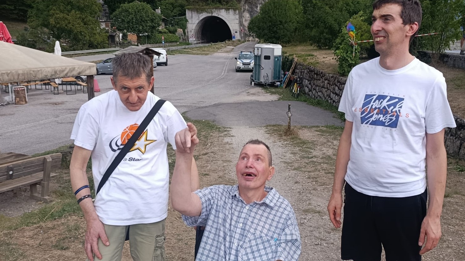 Tre ospiti della Comunit&agrave; Piergiorgio all'aperto guardano verso il cielo, uno di loro indica in alto, mentre seguono le operazioni di spegnimento dell'incendio.